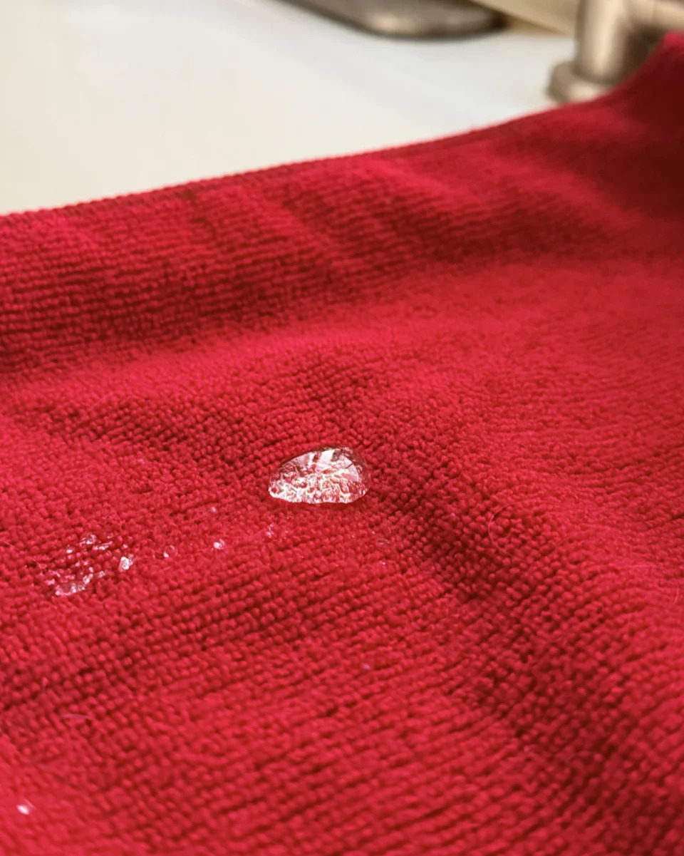 Water droplet on a textured surface, with a reflective effect on the liquid