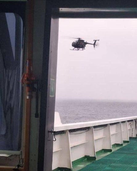 A helicopter flying over an oil tanker