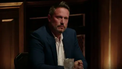 Kieran sitting at the Traitors roundtable