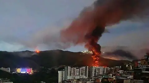 Getty Images Fire at Fuerte Tiuna, Venezuela's largest military complex, is seen from a distance after a series of explosions in Caracas.