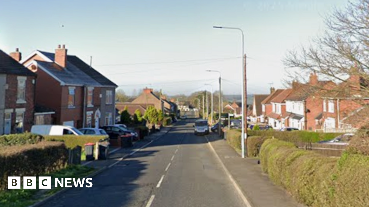 A main road is pictured with houses either side.
