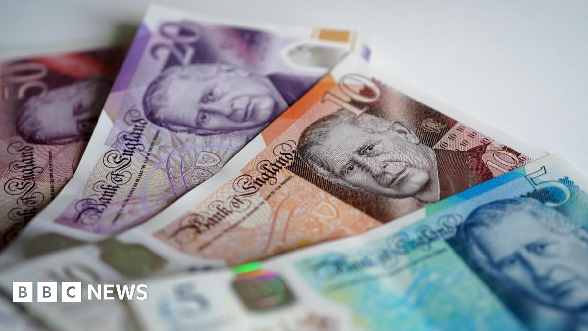 Joan has long blond hair and is wearing a jumper