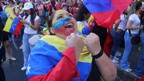 Gabriel Rodriguez/EPA/Shutterstock A Venezuelan woman residing in Panama City celebrates during a demonstration following the capture of Venezuelan President Nicolas Maduro at Urraca Park in Panama City, Panama on 3 January.