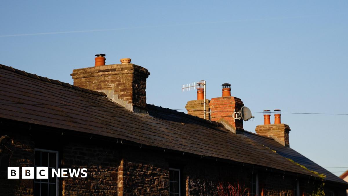 A picture of stone houses with slanted roof tiles and chimneys.