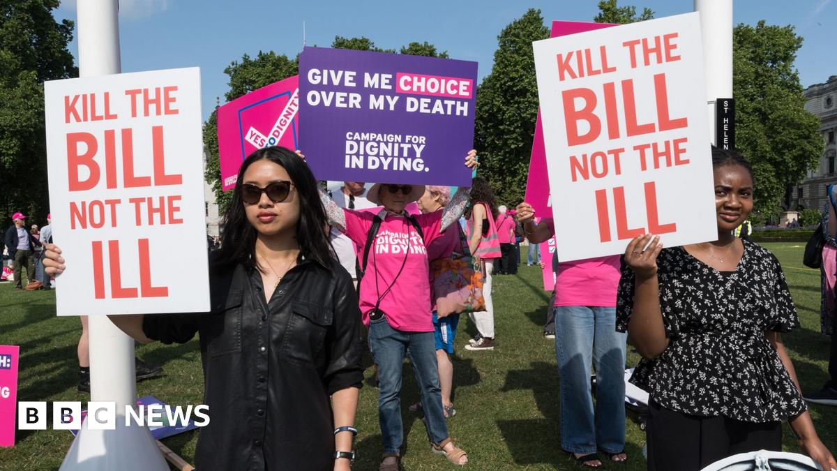 People holding signs saying 'kill the bill not the ill' and 'give me choice over my death' stand protesting outdoors in Parliament Square in early June 2025.