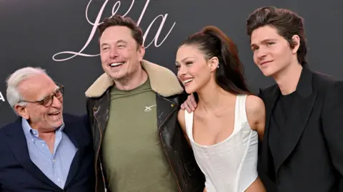 Getty Images Nelson Peltz, Elon Musk, Nicola Peltz Beckham and brother Will Peltz