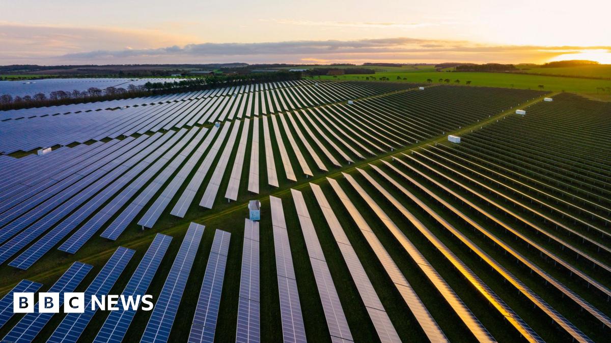 Hundreds of solar panels on rural green fields