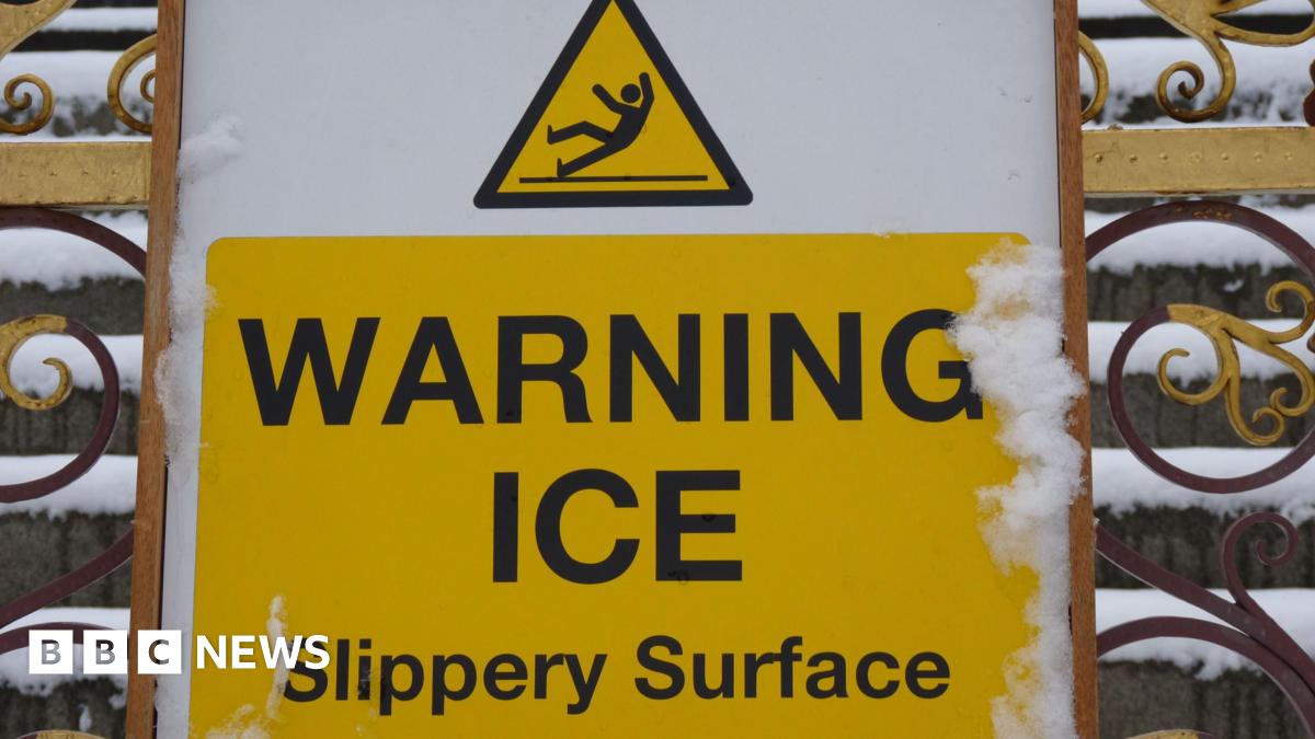 A picture of a yellow sign which reads warning ice slippery surface.