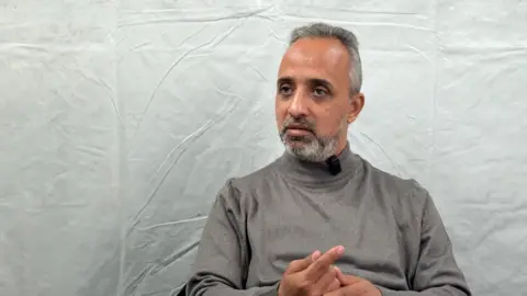 Dr Mohammed Saeed Schheiber, a man in a grey polo neck.