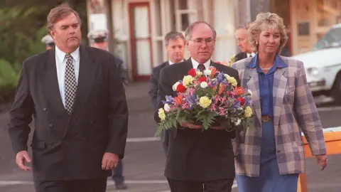 Getty Images Federal Labor Opposition leader Kim Beazley, Prime Minister John Howard, and Democrats leader Cheryl Kernot at Port Arthur. John Howard is holding a wreath