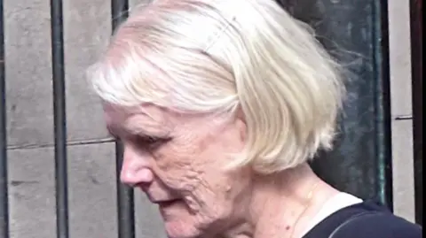 Andrew Lawrie a woman with white/blonde hair in a dark top, pictured outside a court building