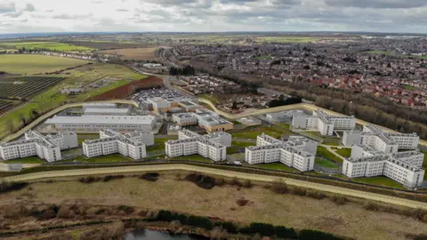 Getty Images An aerial shot of HMP Five Wells showing the seven cross-shaped housing blocks with the town of Wellingborough in the background.