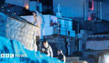 Forensic specialists look for evidence in a cemetery in Corsica in the dark on 12 January