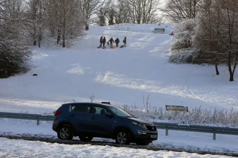 Reuters Children play in the snow as cold and ice weather warnings are extended by Britain's Met Office, in Ballymena, Northern Ireland.