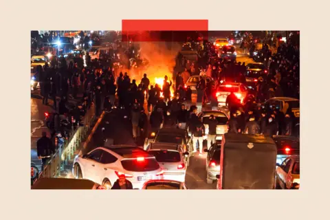 Getty Images People gather on a road during a protest in Tehran, Iran