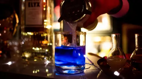 Getty Images A bright blue cocktail being poured at a Los Angeles bar