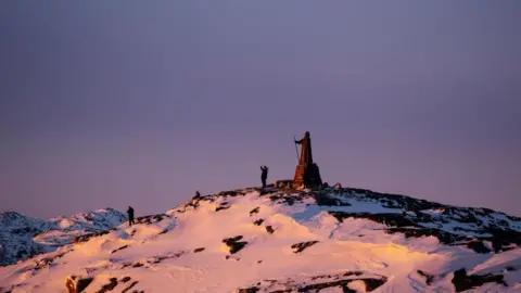 EPA Sun setting on a snow-capped hill in Nuuk