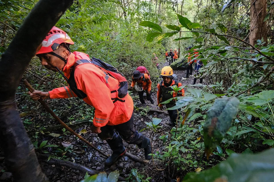Basarnas / Handout/Anadolu via Getty  Indonesia search-and-rescue teams carrying a body of a victim of the Jan. 17 plane crash