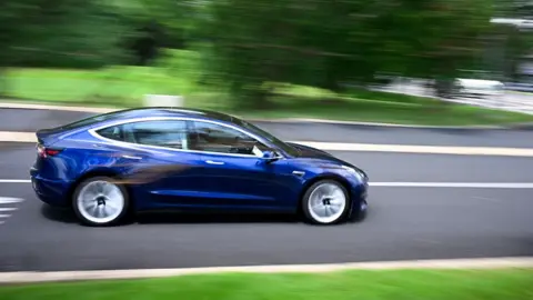 Bloomberg via Getty Images A Tesla vehicle drives off the lot at the company's store in Warminster, Pennsylvania, US, on Tuesday, July 22, 2025. 
