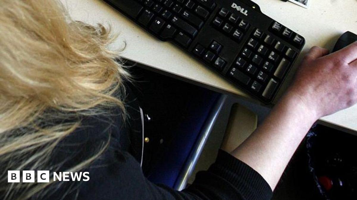 Millie Bobby Brown and David Harbour in character as Eleven and Jim Hopper. Eleven wears red shorts over grey leggings and a grey jumper. Jim Hopper wears a black leather jacket, a black beanie hat and dark trousers.They are speaking to director Frank Darabont on the set of Stranger Things. There is a vintage advertisement posted in the background with debrief on the ground.