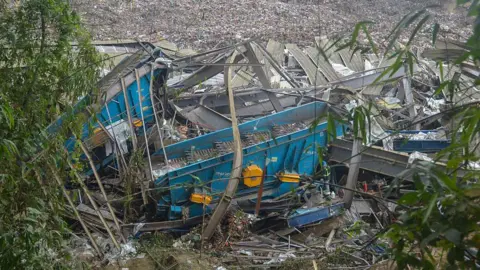 AFP via Getty Images The remnants of a destroyed structure, including bent metal pieces, lie at a landfill site in Cebu surrounded by rubbish.