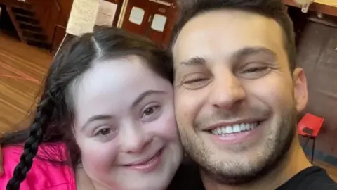 Ellie Goldstein Ellie wearing pink takes a smiling selfie with Vito