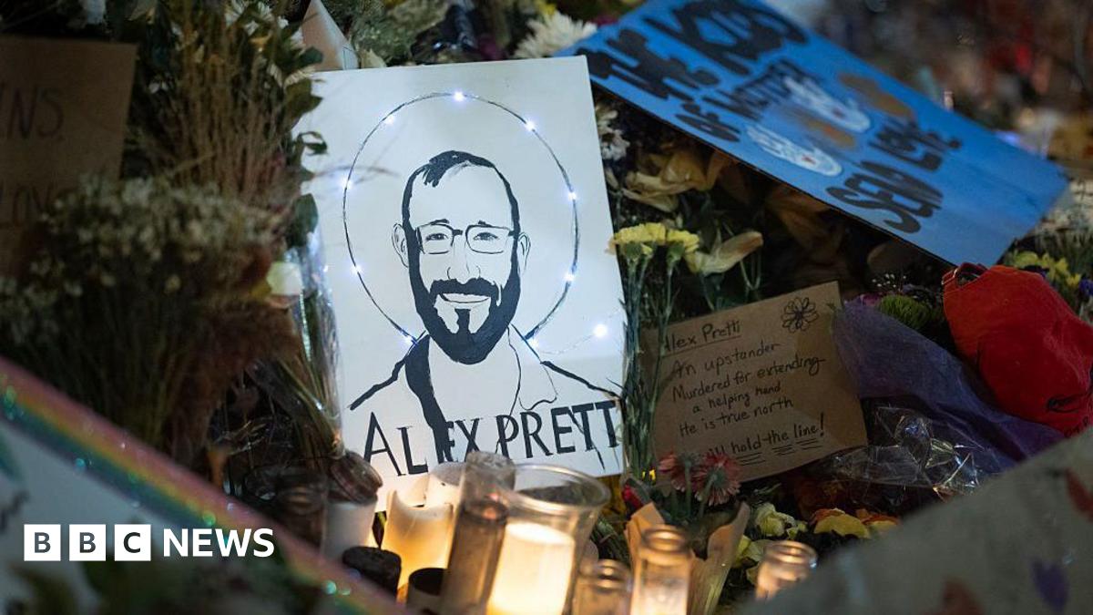 close-up of signs, flowers, and candles dedicated to Alex Pretti