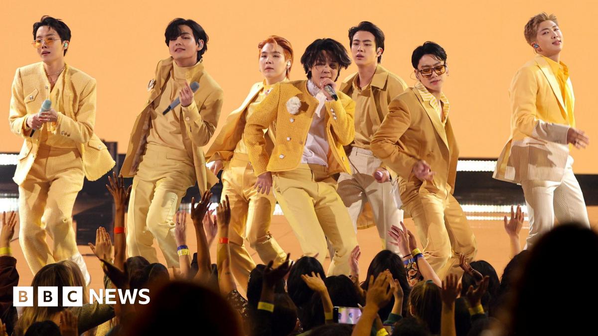 BTS on stage in matching yellow suits