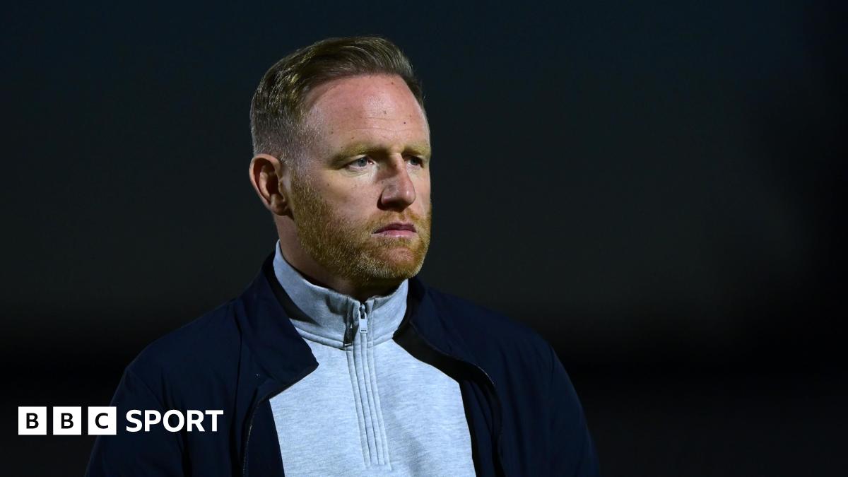 Brackley Town manager Gavin Cowan looks on from the touchline during a night game