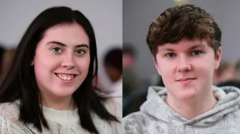 A young woman with shoulder-length black hair, wearing a white top and a young man with brown hair wearing a hooded top