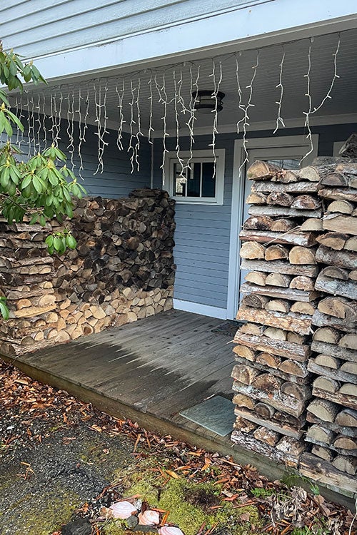 Wood stacked neatly in rows outside a back door.