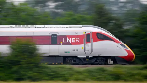 Getty Images A white and red LNER train speeds through countryside