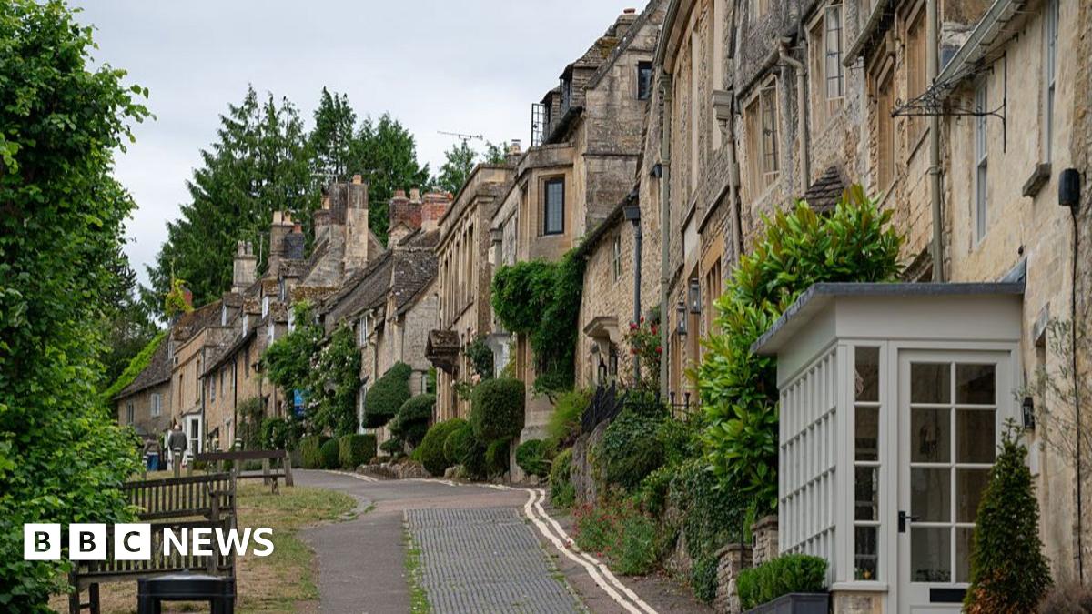 Prime Minister Mark Carney, wearing a black suit jacket, and a white button-up shirt leans his chin on his hands. He has short grey and black hair and is looking away from the camera.