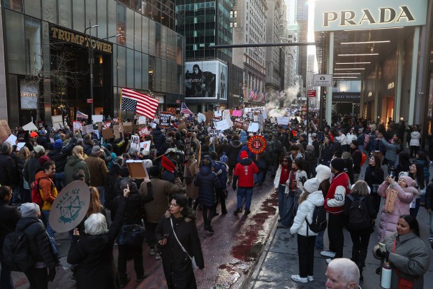 Demonstrators march past Trump Tower on Fifth Avenue in Manhattan during a protest against war in Venezuela and ICE on Sunday.