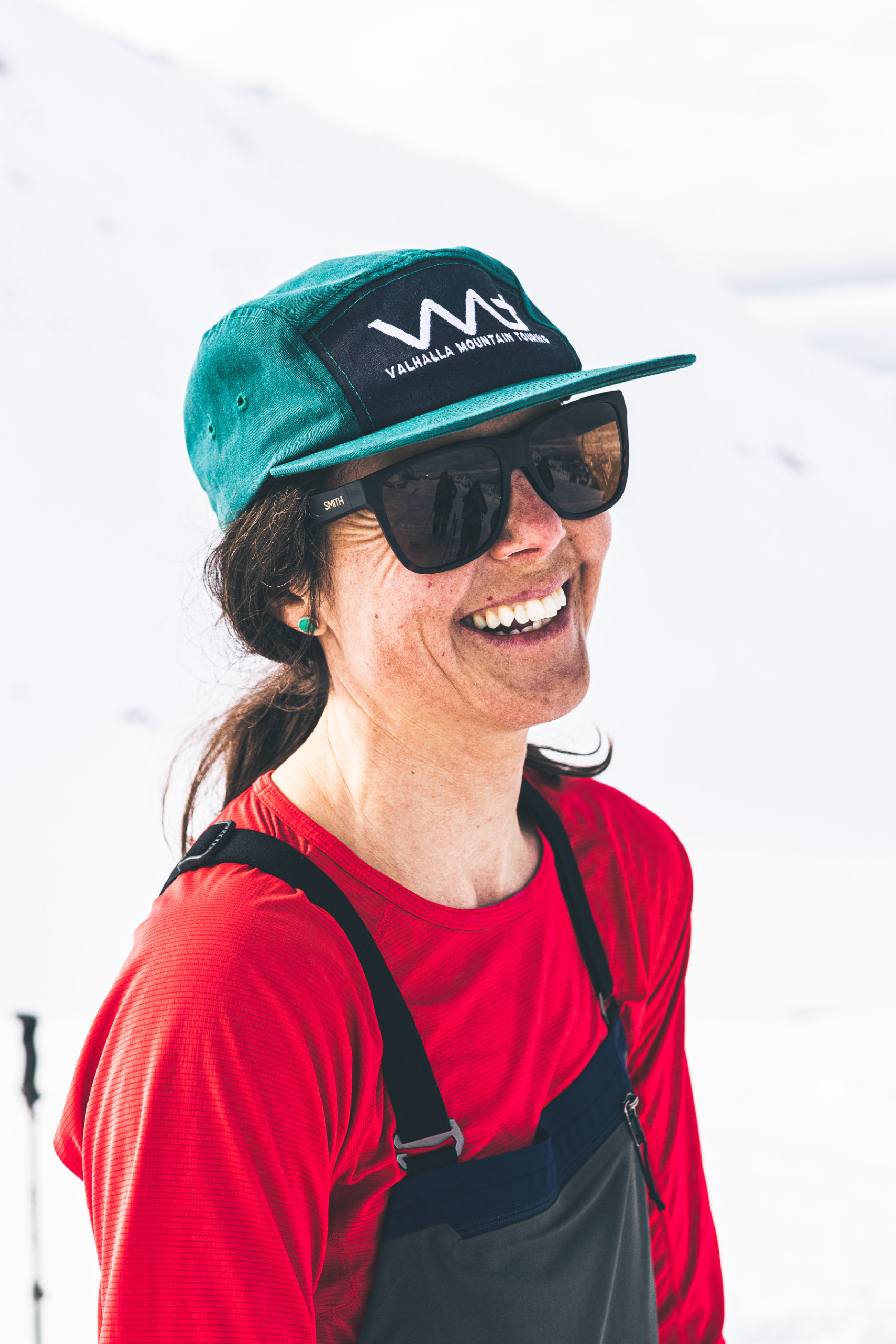 Mountain guide Jasmin Caton stands in a snowy landscape and smiles.