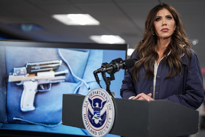 A photograph of a pistol recovered by immigration agents after the fatal shooting of Alex Pretti in Minneapolis is shown on a screen behind Secretary of Homeland Security Kristi Noem during a news conference at FEMA headquarters on January 24, 2026 in Washington, D.C.