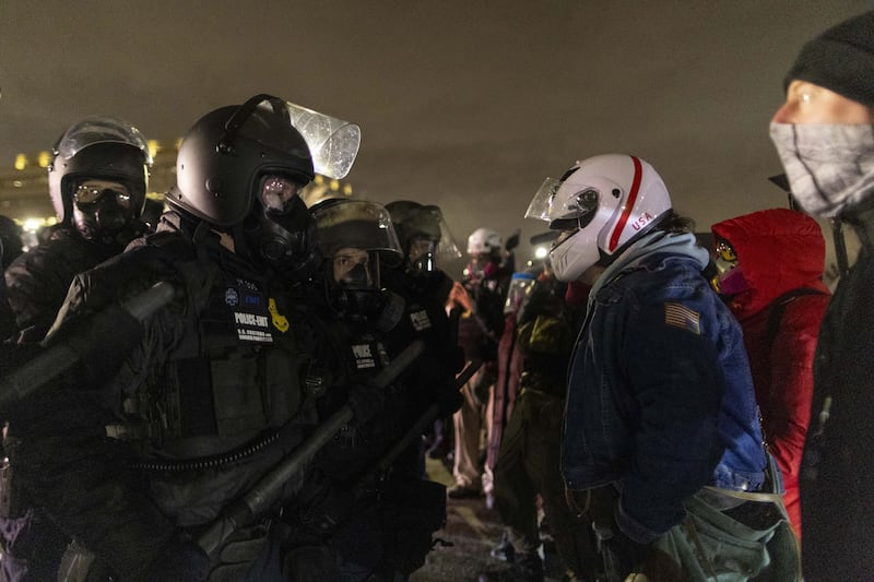 Federal immigration officers confront protesters outside Bishop Henry Whipple Federal Building in Minneapolis as tensions remain high following Renee Good's death.