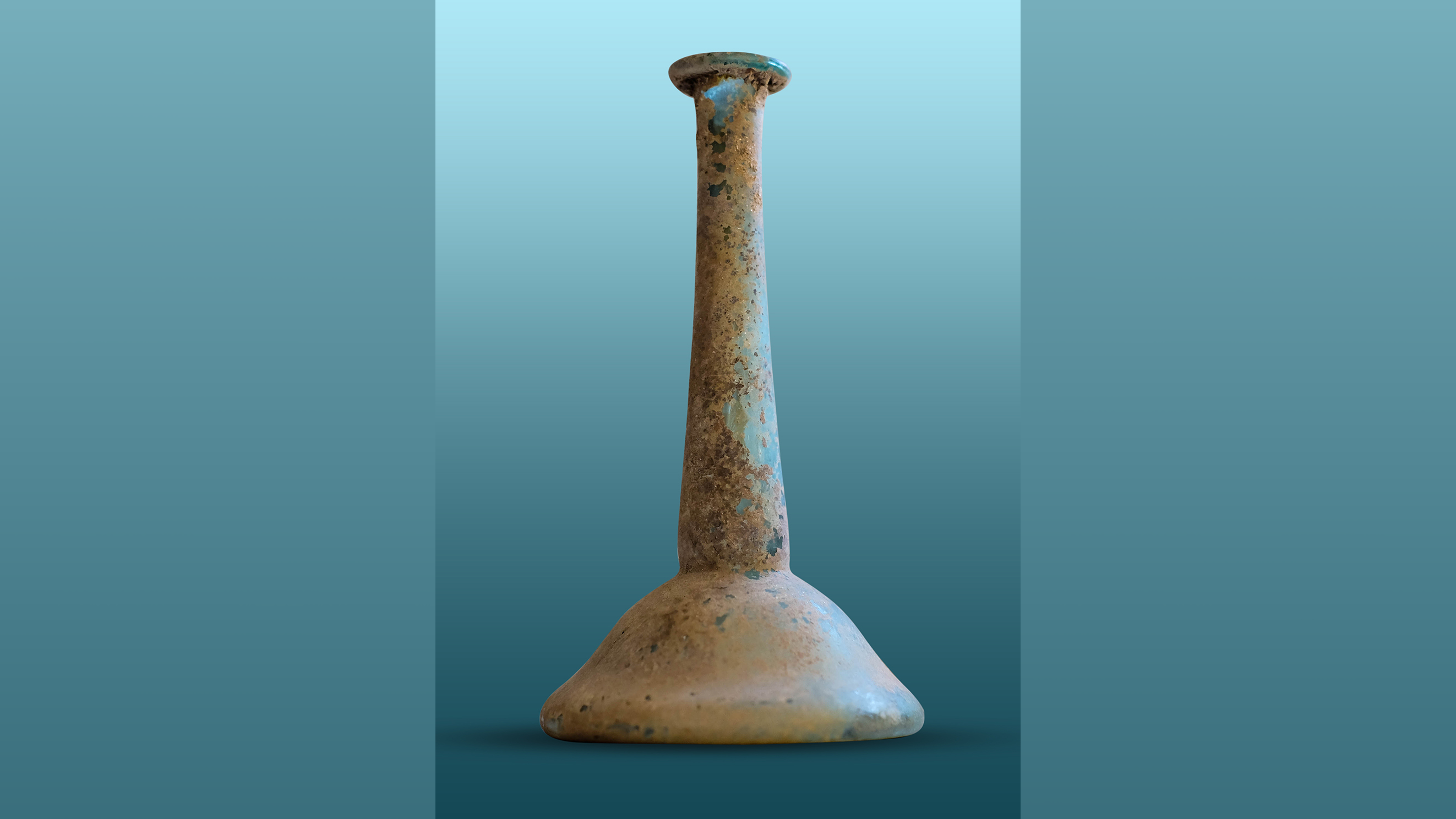 candlestick-shaped Roman glass jar against a light teal background