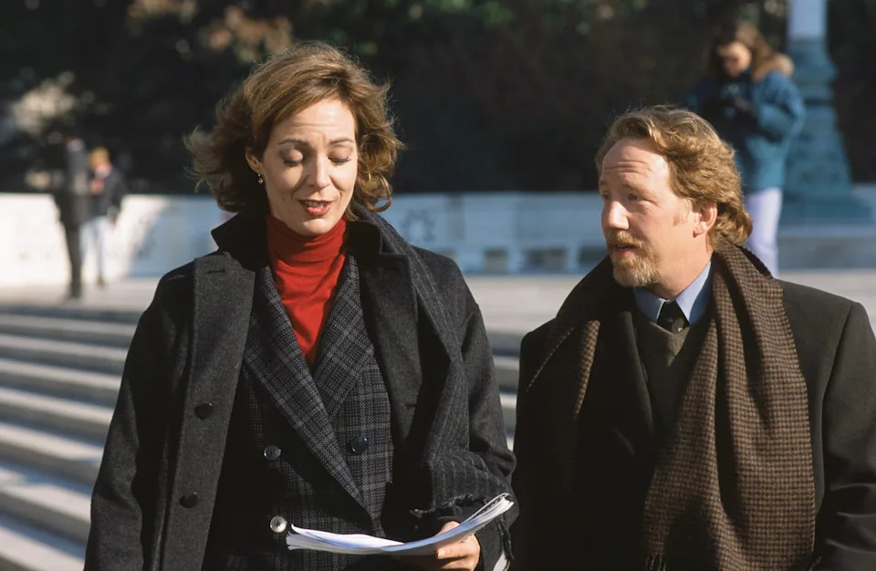 Allison Janney and Timothy Busfield walk together in 1999 in a scene from West Wing. 