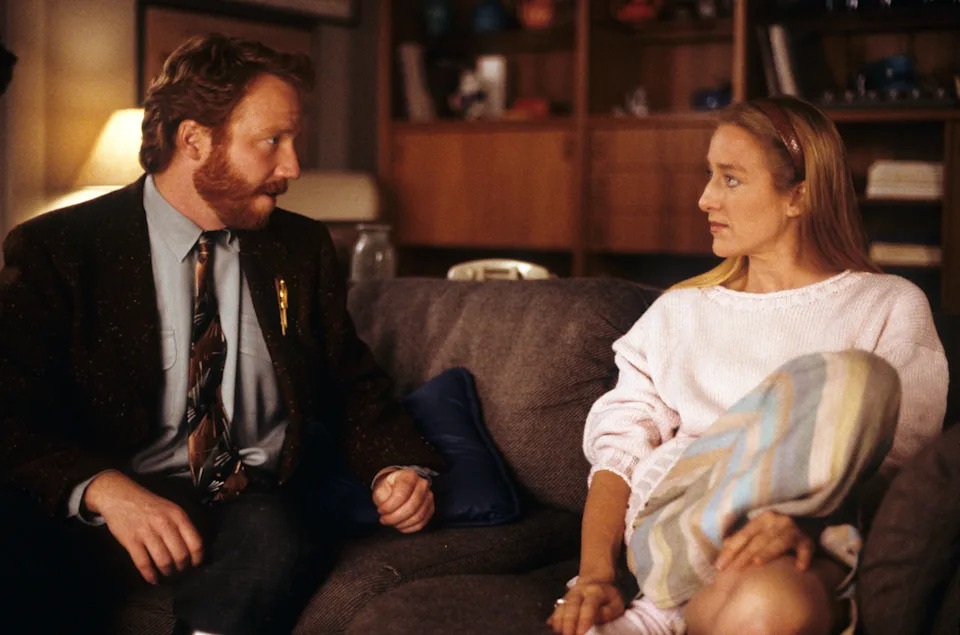 Timothy Busfield and Patricia Wettig sit on a couch in 1989 in a scene from Thirtysomething. 