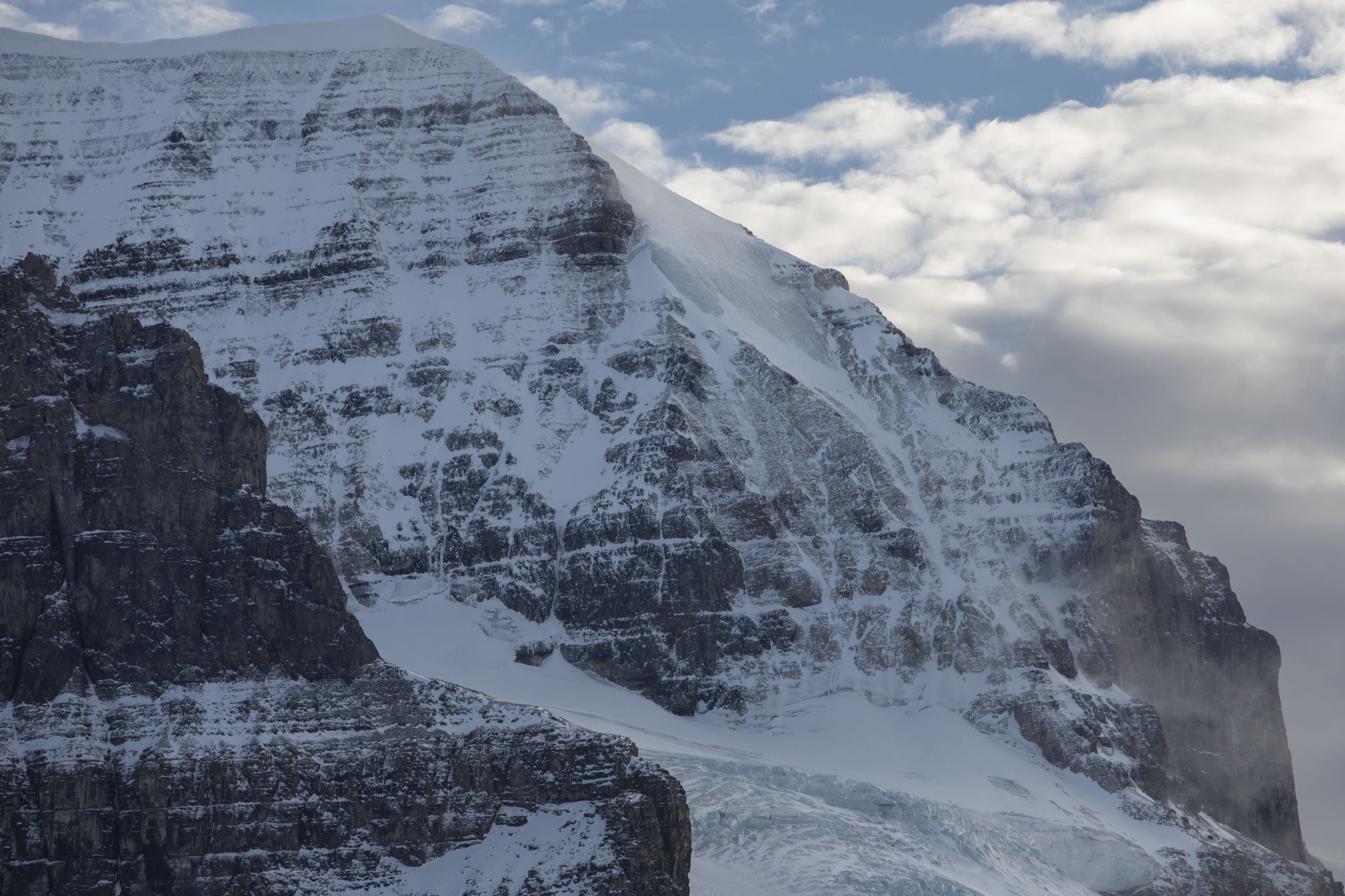A photo of a rock face with some snow and some exposed rock due to glacier melt