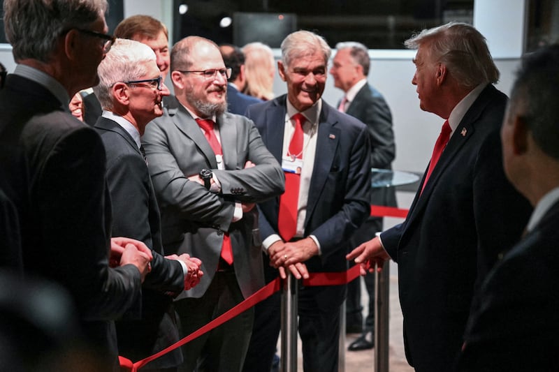 US President Donald Trump (2R) speaks with US businessman Tim Cook (2L) during a reception with business leaders on the sidelines of the World Economic Forum (WEF) annual meeting in Davos on January 21, 2026. The World Economic Forum takes place in Davos from January 19 to January 23, 2026. (Photo by Mandel NGAN / AFP via Getty Images)