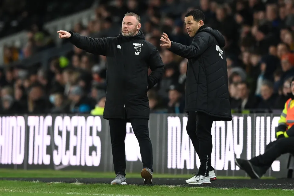 Wayne Rooney, Manager of Derby County and assistant coach Liam Rosenior react during the Sky Bet Championship match between Derby County and Millwall at Pride Park Stadium 