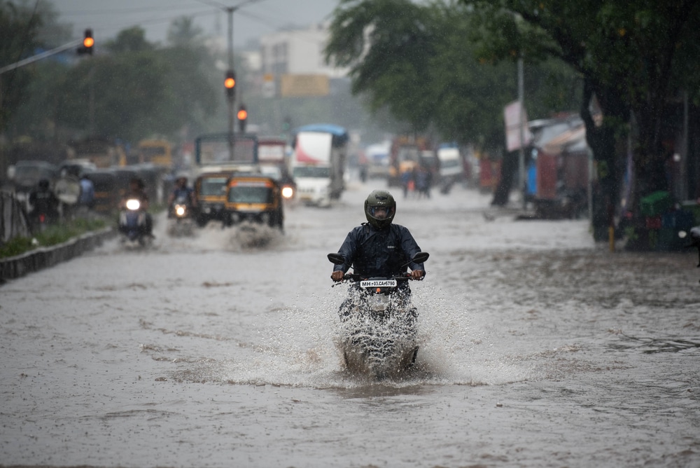 A Man Rides A Motorcycle Through A Flooded Street During Heavy Rains At Kurla