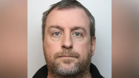 Wiltshire Police Police head and shoulders image of Young, who has short greying hair and a brown/grey beard.