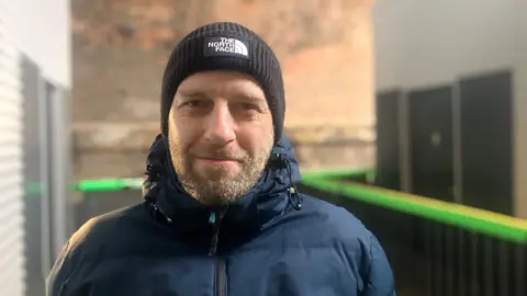 Photograph of Arran Ashcroft from Rusholme. He is pictured at the Embassy homeless village in Castlefield.