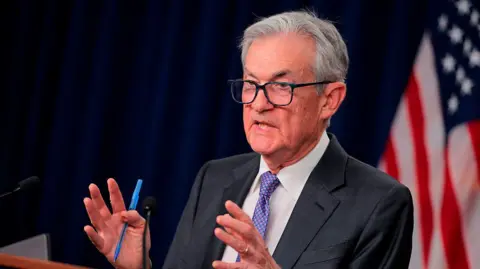 Getty Images Jerome Powell seen speaking at a podium. He is motioning with his hands 