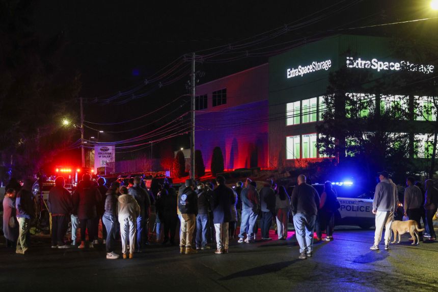 People gather December 18 outside a storage facility where the suspect in the shootings at Brown University and of an MIT professor was found dead.