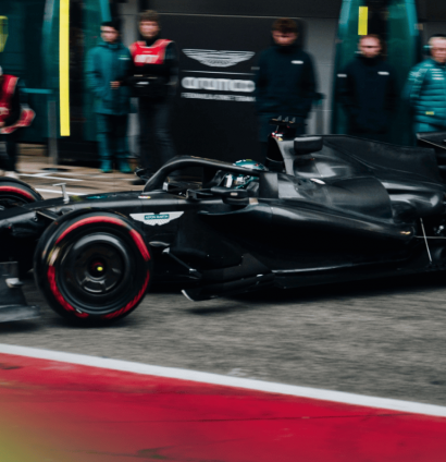 Lance Stroll leaves the garage in an all-black Aston Martin AMR26