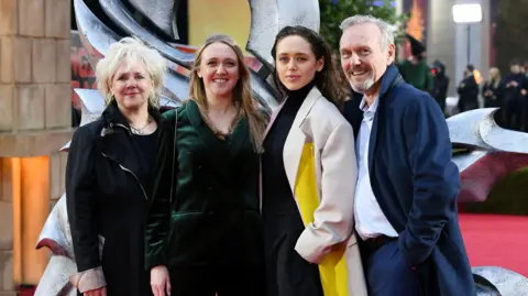 Getty Images Sarah Fisher, Emily Head, Daisy Head and Anthony Head attend the "Dungeons & Dragons: Honour Among Thieves" UK Premiere at Cineworld Leicester Square on March 23, 2023. They are standing together smiling at the camera, all wearing coats.